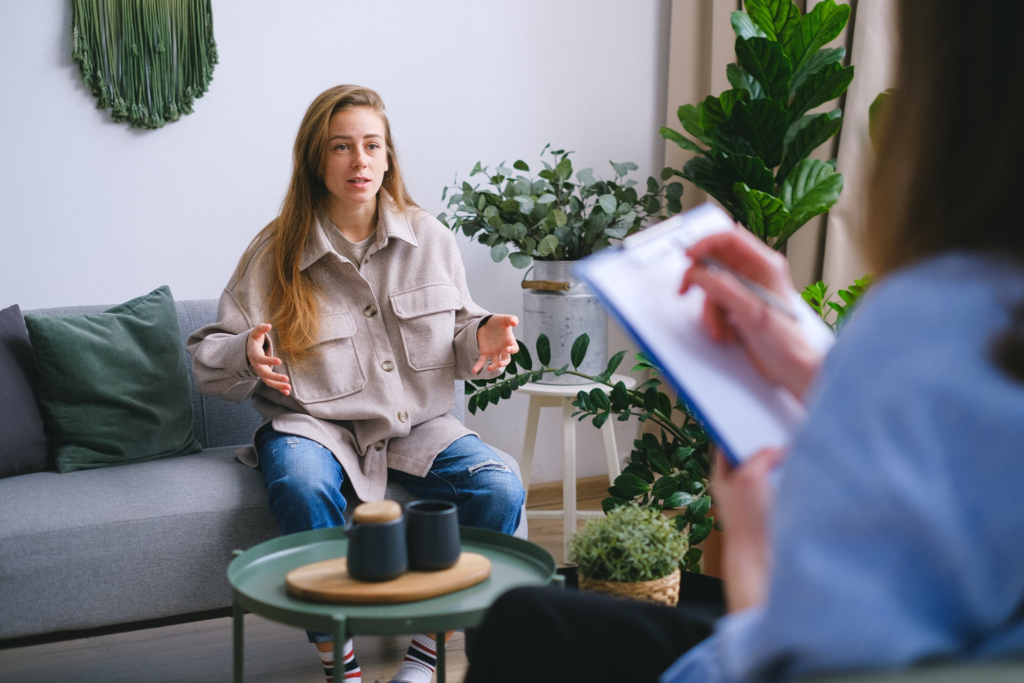 female sitting on sofa while talking in room during psychotherapy session