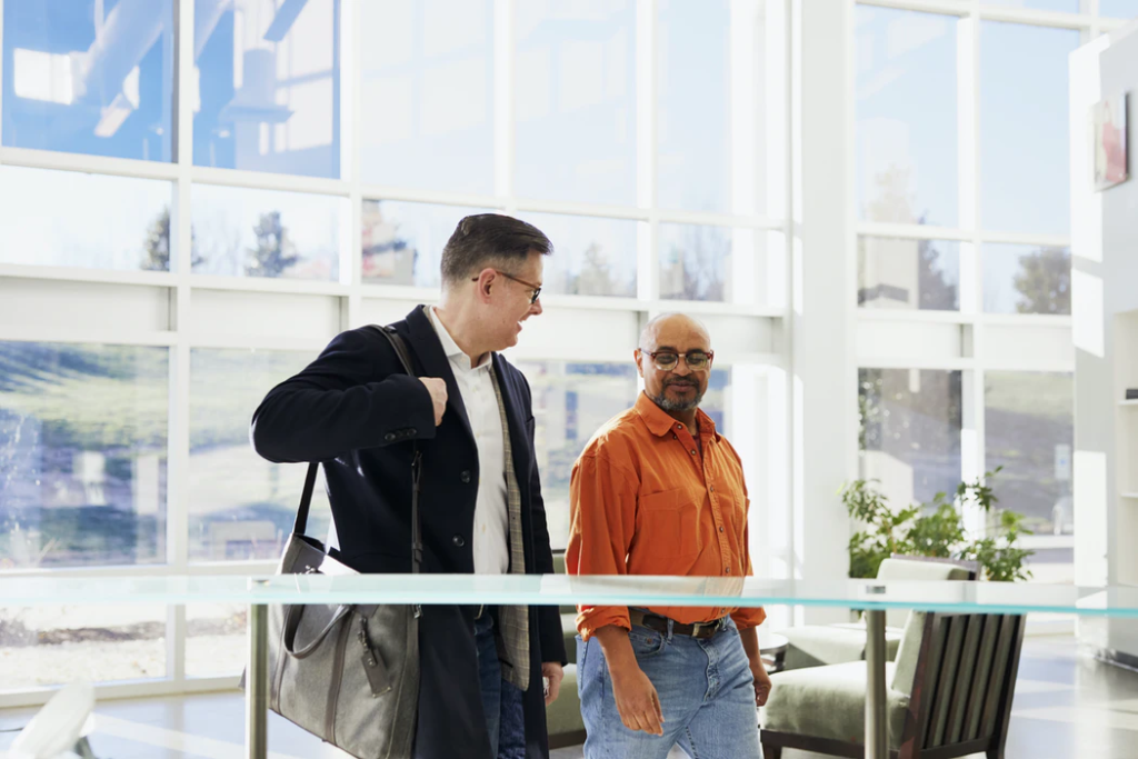 Two business colleagues conversing in office building.