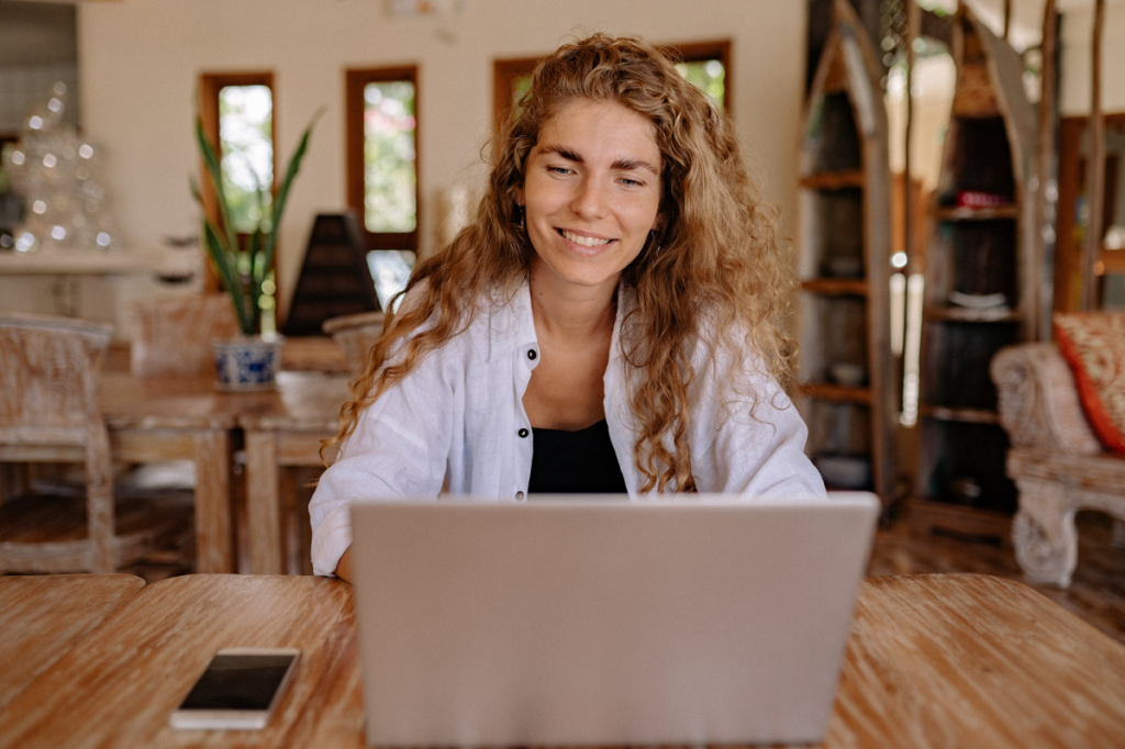 Woman using laptop while smiling