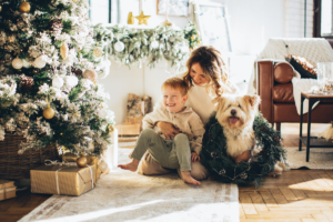 A young mother with her son and a dog at a christmas tree